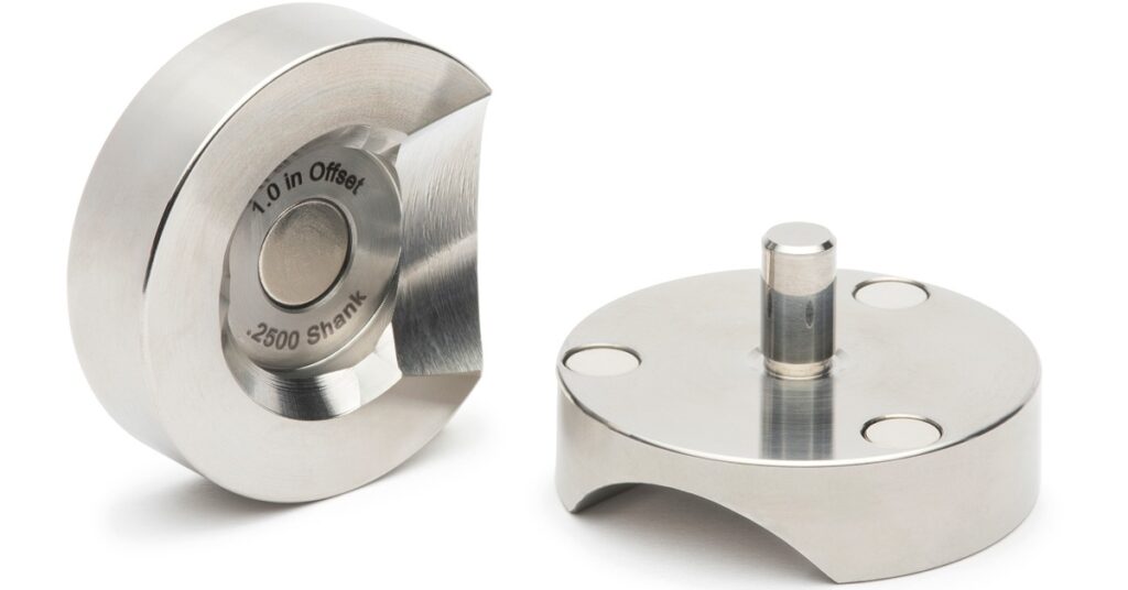 Two silver mounting metal parts with circular openings, engraved text, raised centers, and curved cutouts.