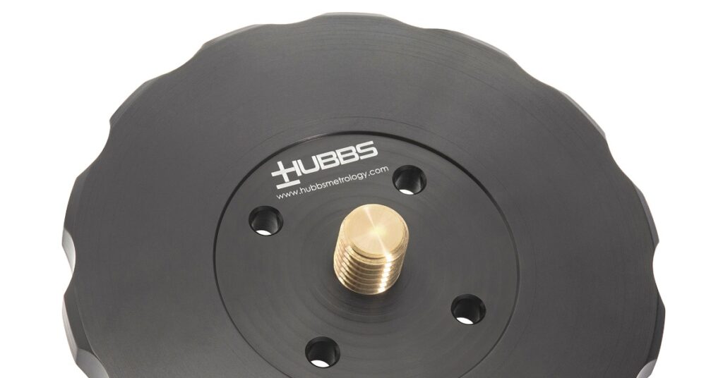 A black round machined part with a brass threaded center, scalloped edges, and 'HUBBS' in white lettering.