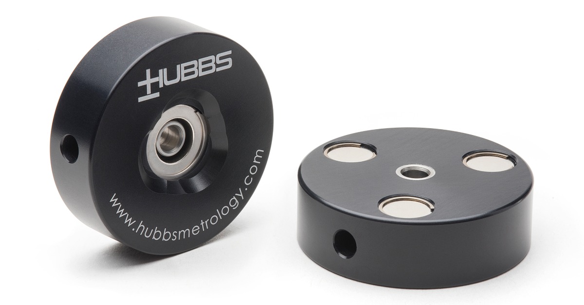 Two black circular metal components with machined openings, silver inserts, and HUBBS lettering on a white surface.
